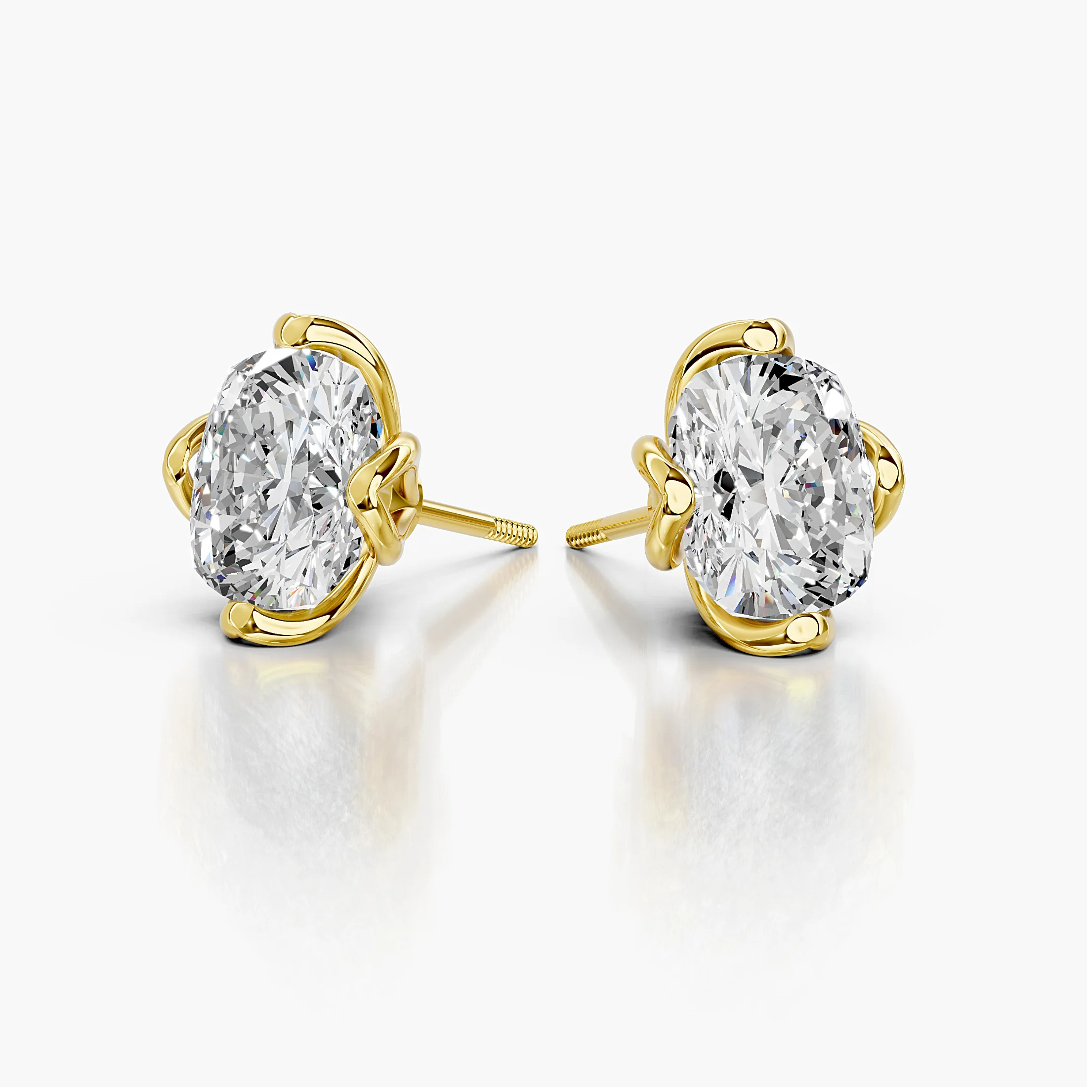 Cushion-cut diamond solitaire stud earrings with sculpted four-prong settings.