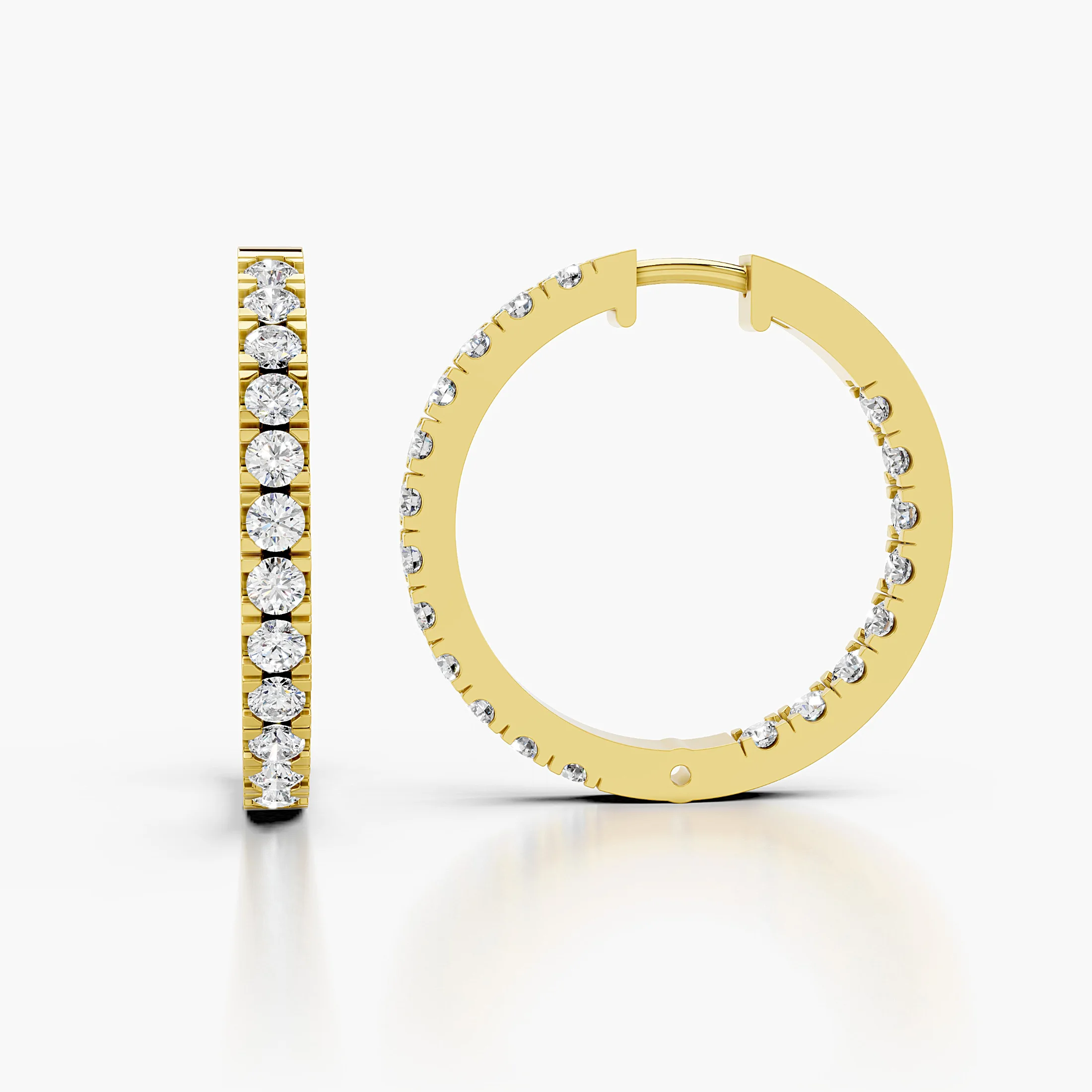 Pair of graduated round diamond hoop earrings with front-facing prong-set stones and slim polished edges.