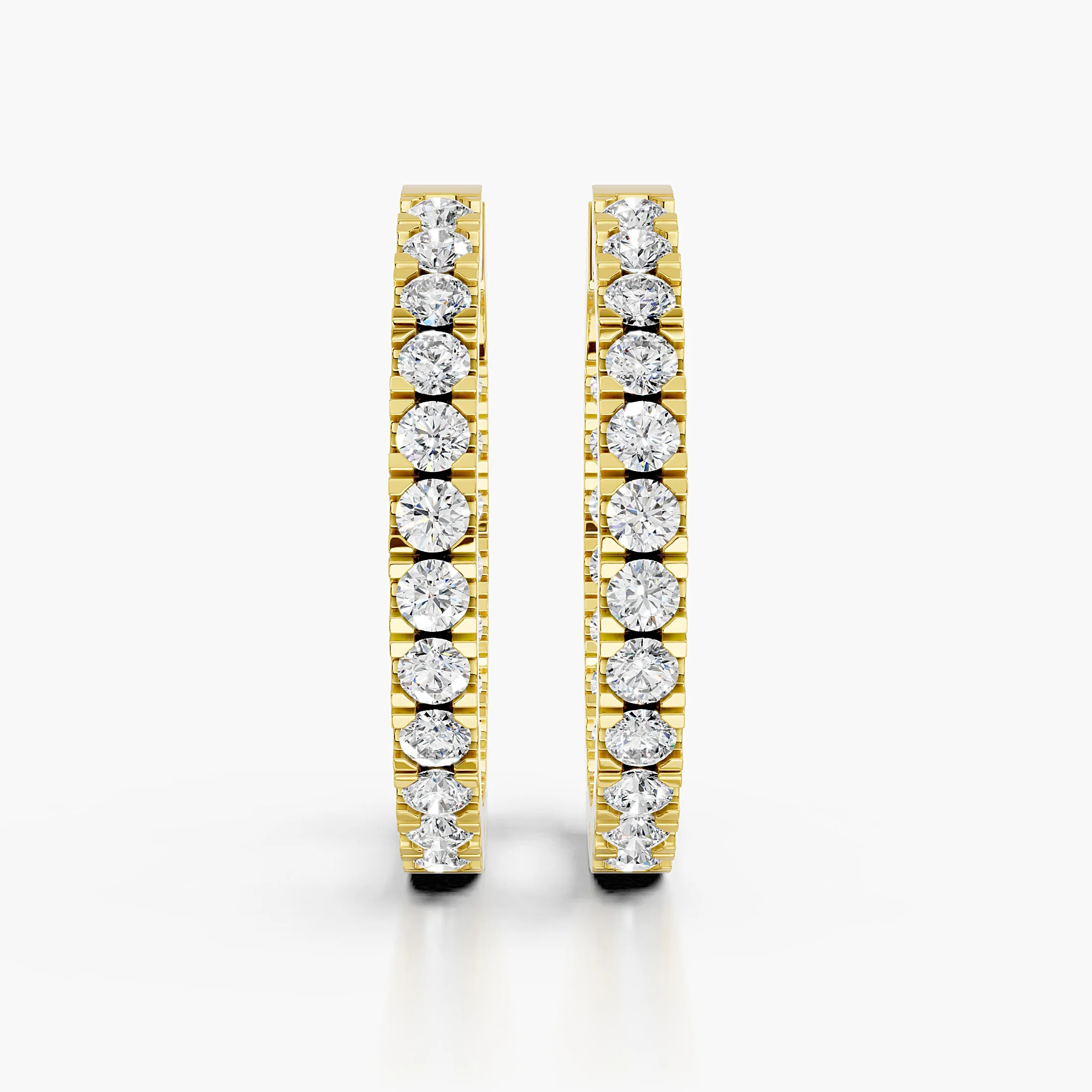 Pair of graduated round diamond hoop earrings with front-facing prong-set stones and slim polished edges.