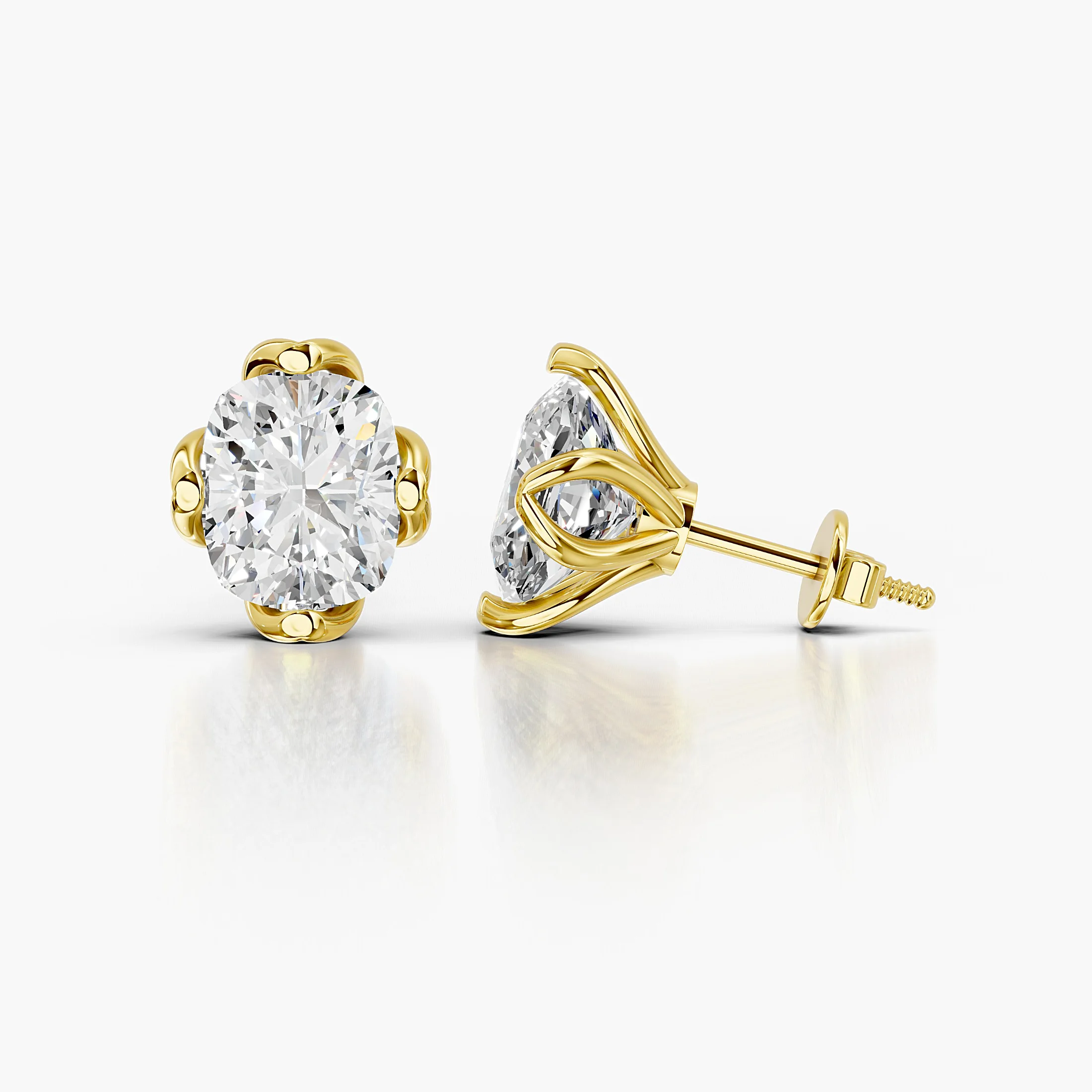 Cushion-cut diamond solitaire stud earrings with sculpted four-prong settings.