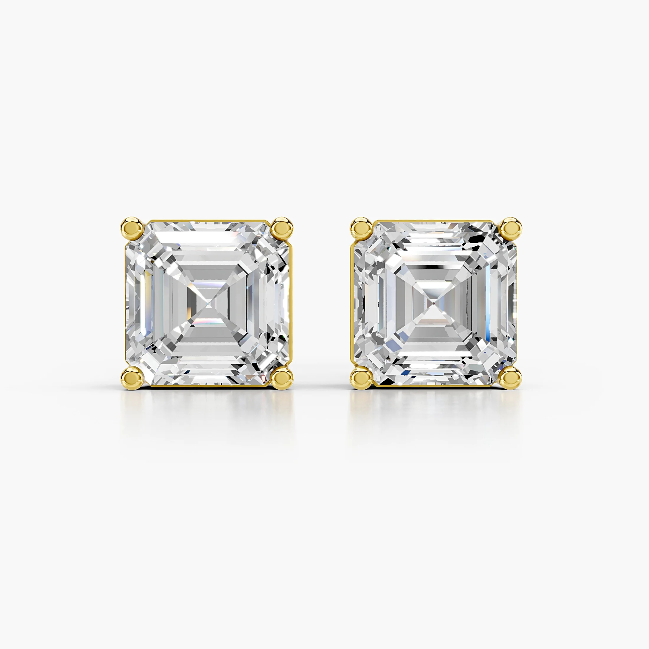 Pair of emerald-cut lab-grown diamond solitaire stud earrings in four-prong settings.