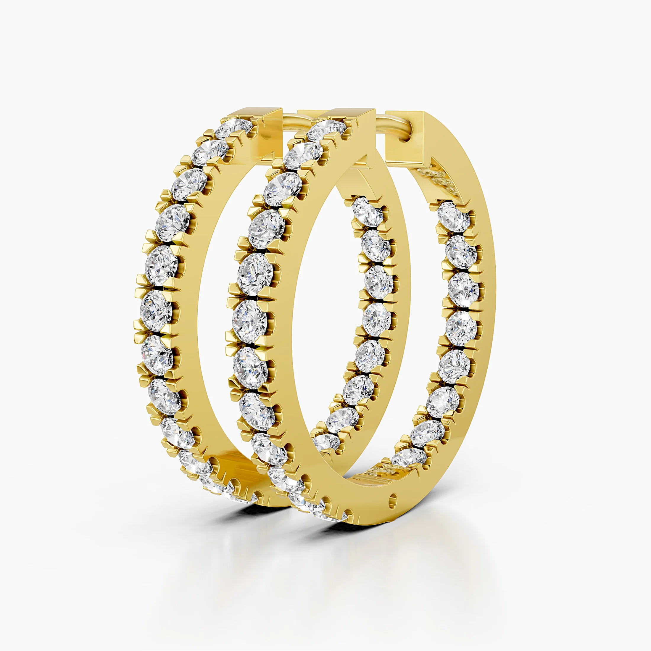 Pair of graduated round diamond hoop earrings with front-facing prong-set stones and slim polished edges.